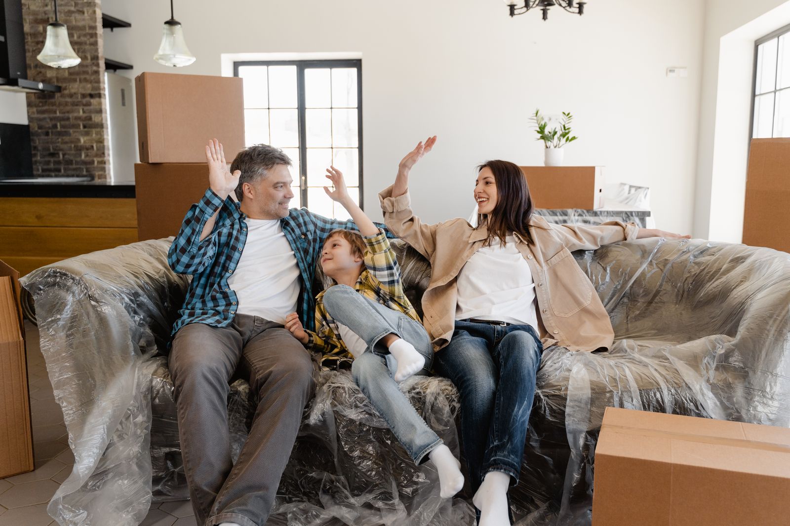 Familie freut sich in ihrem neuen Zuhause zwischen Umzugskartons